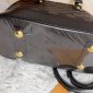 Bottom view of the Louis Vuitton-style Alma replica bag showing protective gold feet and leather finish
