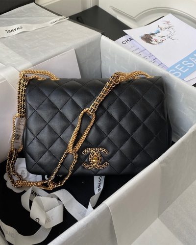 Black Chanel flap bag with woven chain CC lock inside its gift box