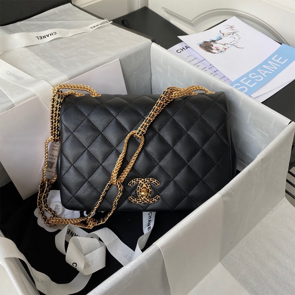 Black Chanel flap bag with woven chain CC lock inside its gift box