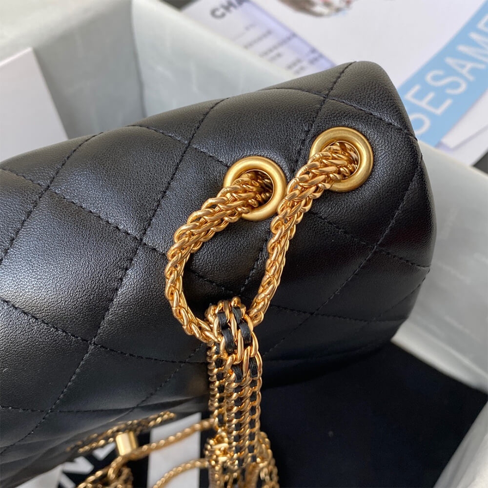 Gold eyelets and rope chain close view on black Chanel flap bag