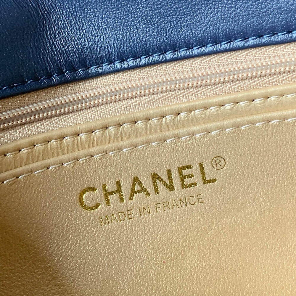 Gold lining with Chanel stamp close view inside navy mini flap bag