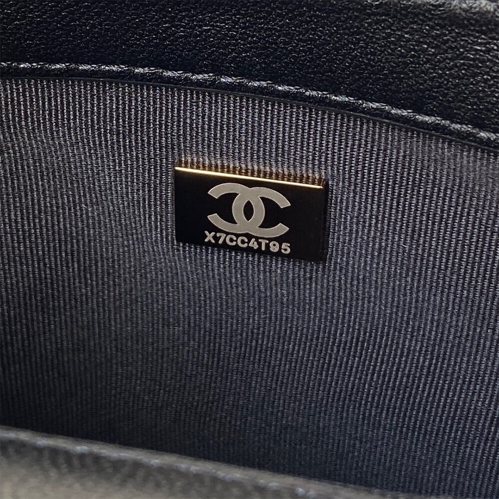 Metal CC chip plate close view inside black Chanel flap bag