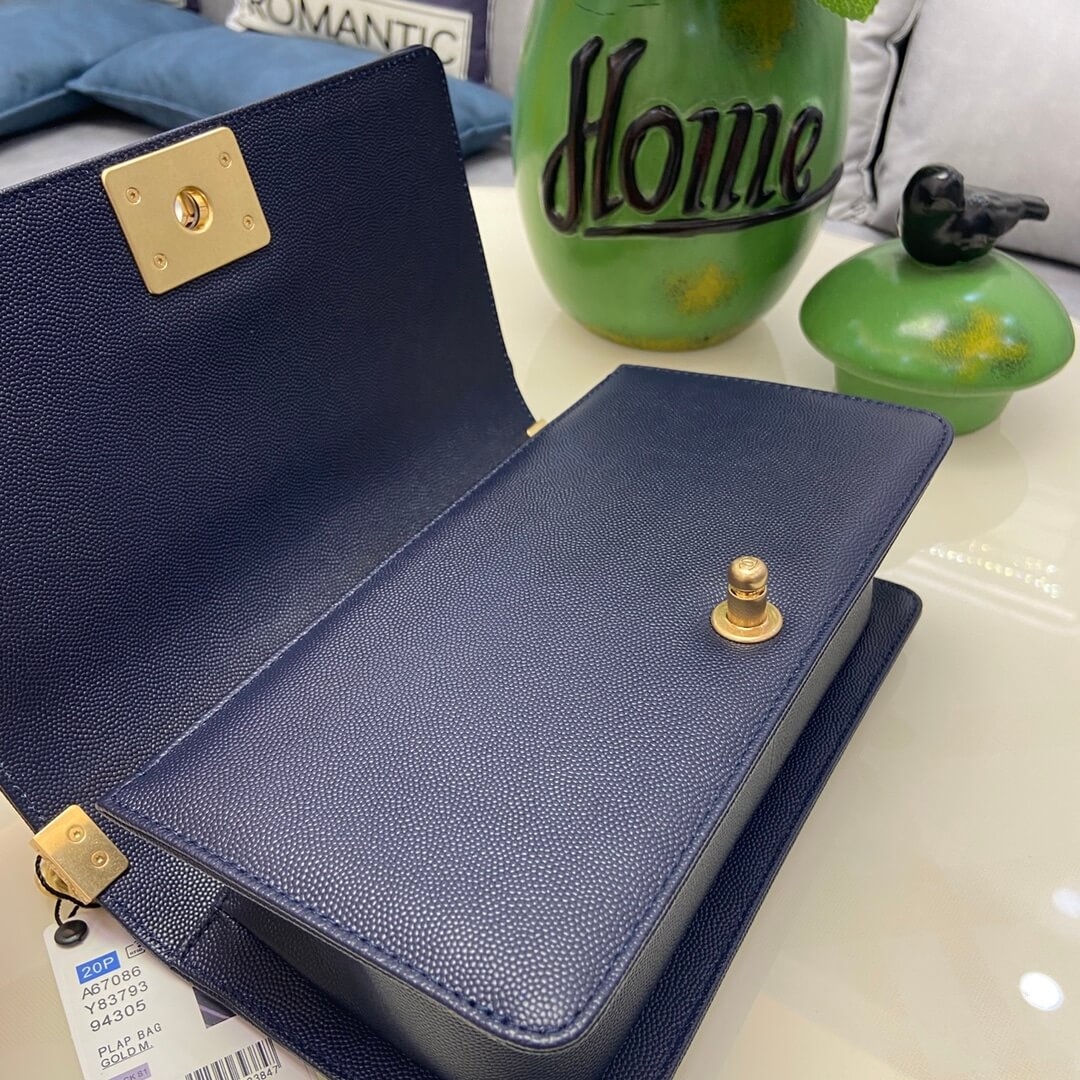 Open flap of navy Boy Chanel bag showing the gold lock plate