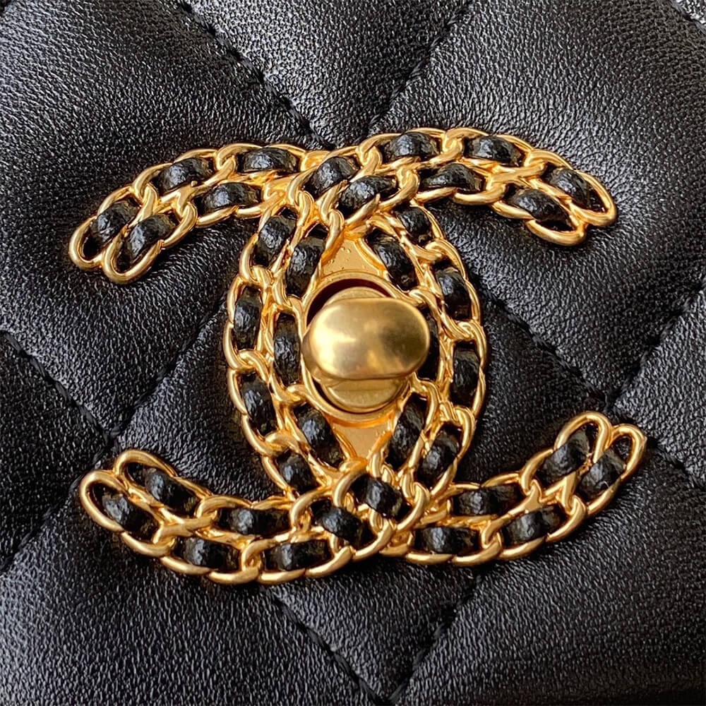Woven gold chain CC turn lock close view on black lambskin flap bag